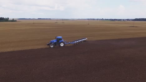 Blauer-Moderner-Pflügender-Traktor,-Der-Auf-Dem-Feld-Arbeitet