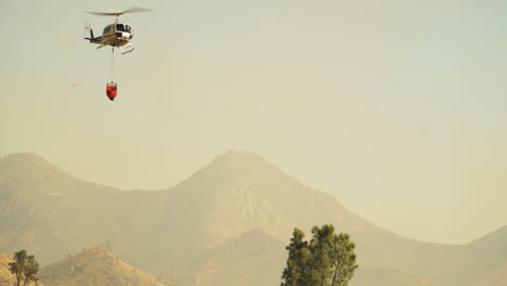 Helikopter-Brandbekämpfung-Aus-Der-Luft-Mit-Wassereimer,-Wasserbombenangriff-Auf-Buschfeuer