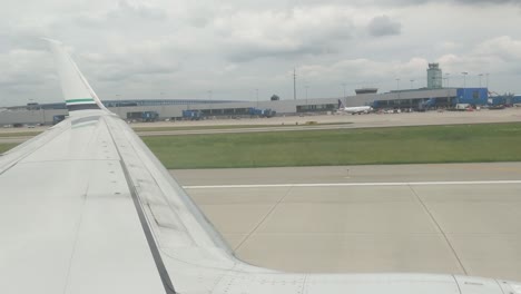 Looking-out-over-the-wing-as-the-plane-takes-off-from-Detroit-Metro,-DTW,-cloudy