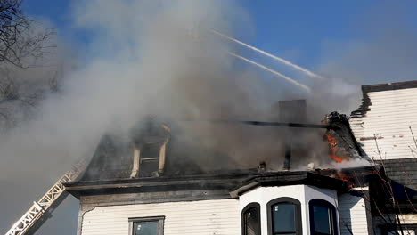 Bomberos-Rociando-Agua-Desde-Una-Escalera-Alta-Sobre-Un-Histórico-Incendio-En-Una-Casa-Victoriana-En-Connecticut