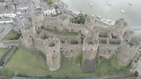 Mittelalterliches-Wahrzeichen,-Historisches-Conwy-Castle,-Luftaufnahme-über-Der-Walisischen-Küstenlandschaft,-Darunter-Vorbeifahrender-Zug