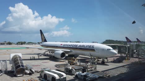 Vista-Panorámica-Del-Paisaje-Dentro-De-La-Terminal-Del-Aeropuerto-En-El-Aeropuerto-Internacional-De-Phuket-Con-El-Avión-Boeing777-200-Singapore-Airline-Plane-4k-Uhd-Video