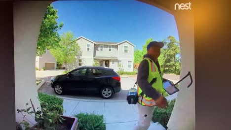 Imágenes-De-Nest-Cam-De-Un-Hombre-Vestido-Con-Un-Uniforme-Pg-e-Tocando-El-Timbre-De-Una-Casa-Residencial