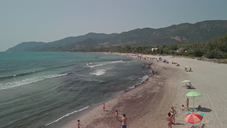 Familia-Con-Niños-Divirtiéndose-En-Una-Playa-Tropical-En-San-Teodoro,-Cerdeña,-Italia-En-Verano