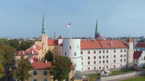 Riga-castle-exterior-seen-from-above,-aerial-drone-circling-around,-Latvia,-day