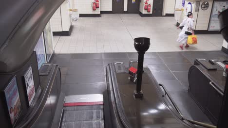 London-underground-escalators-and-crowd-of-people-going-down,-static-cinematic-view