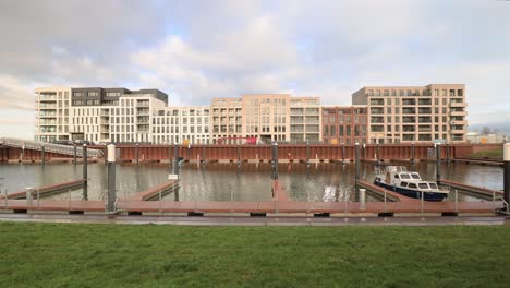 Zeitraffer-Von-Vorbeiziehenden-Wolken-über-Einem-Neu-Gebauten-Freizeithafen-Mit-Wasserstandsänderungen-Und-Dem-Bau-Eines-Modernen-Luxusapartments-Im-Hintergrund