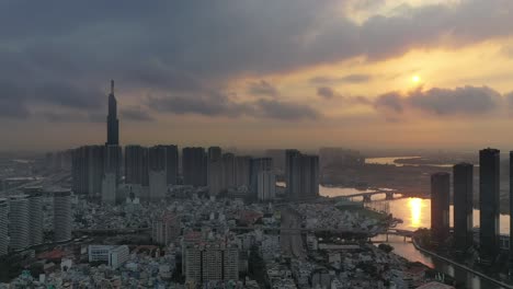 Espectacular-Toma-De-Drones-Al-Amanecer-De-La-Ciudad-De-Ho-Chi-Minh,-Panorámica-De-Izquierda-A-Derecha,-Comenzando-Con-Desarrollos-Históricos-Y-Del-Parque-Central-Y-Terminando-Con-El-Desarrollo-Del-Río-Dorado