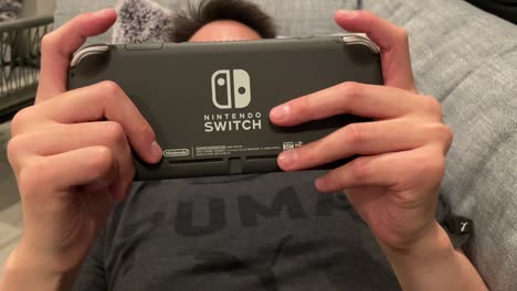 Tipo-Jugando-Juegos-De-Nintendo-Switch-Mientras-Está-Acostado-En-El-Sofá