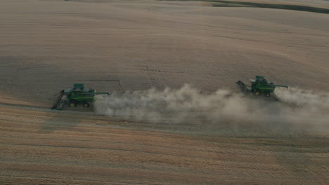 Vista-Panorámica-Lateral-De-Drones-De-Dos-Cosechadoras-Trabajando-En-Un-Campo-De-Trigo-Durante-La-Cosecha