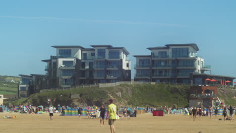 Tourists-Wandering-Around-The-Sandy-Coastline-Of-Perran-Beach-In-Front-Of-The-Dunes-In-Perranporth,-United-Kingdom