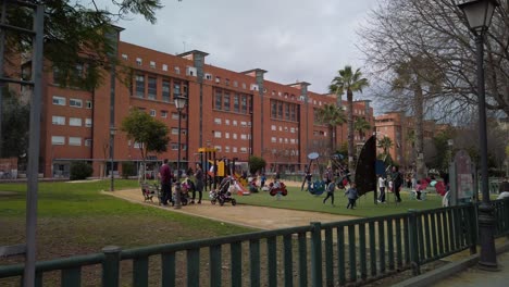 Kids-play-on-playground-with-parents,-Slow-Motion-Wide-Dolly-In