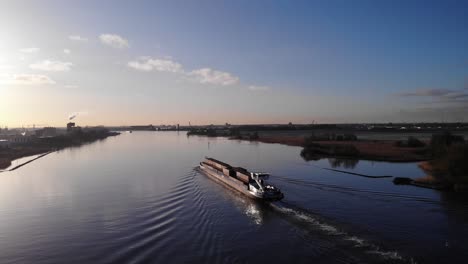 Barcaza-Cornelis-r-Con-Mercancías-Navegando-En-El-Río-Noord-Durante-La-Puesta-De-Sol-En-Holanda-Del-Sur,-Países-Bajos