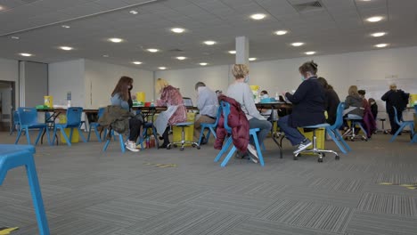 People-sitting-waiting-preparing-to-take-covid-virus-AstraZeneca-vaccine-jab-in-UK-centre