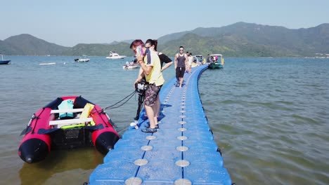 Einheimische-Gehen-An-Einem-Sommertag-Auf-Einem-Kleinen-Pier-In-Hongkong-Mit-Kleinen-Booten-Im-Wasser