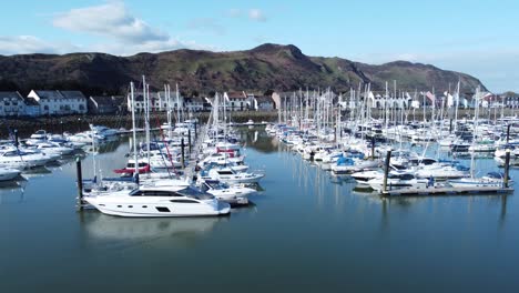 Yates-Y-Veleros-De-Lujo-Amarrados-En-Conwy-Marina-Mountain-Waterfront-Vista-Aérea-Del-Norte-De-Gales-Dolly-Baja-Izquierda