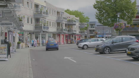 Coche-Pequeño-Que-Sale-Del-Estacionamiento-En-Un-Pequeño-Centro-Comercial-En-Los-Países-Bajos