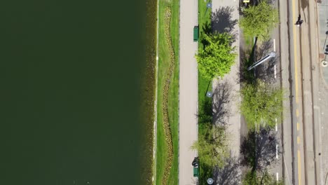 Vorwärts-Bewegte-Antenne-Des-Parks-Mit-Spaziergängern-Und-Teich-Mit-Wasser-In-Der-Nähe-Der-Eisenbahn---Geteilter-Bildschirm-Von-Lungegaard-Bergen