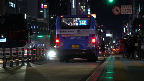 Pendler-Tragen-Maske-An-Der-Bushaltestelle,-Steigen-Ein-Und-Warten-Während-Der-Hauptverkehrszeit-In-Der-Nacht