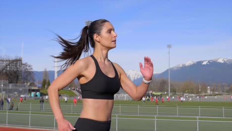 Young-athletic-woman-running-along-track-outdoor