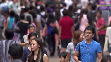 Beautiful-asian-girl-with-black-hair-using-a-tissue-to-clean-nose-after-a-cold-or-having-allergies-standing-outside-in-crowded-busy-street