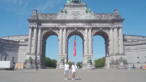 Still-static-shot-of-the-Cinquantennaire-triumphal-arc-monument-in-Brussels,-Belgium,-on-warm-sunny-summer-day-with-blue-skies,-with-construction-crane-above-the-monument-in-distance