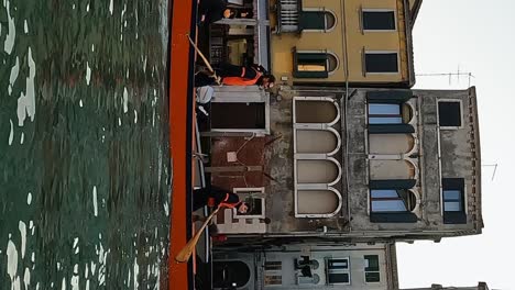 Team-of-four-rowers-training-rowing-standing-on-Venetian-canal-of-Venice-in-Italy