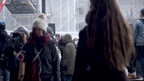 Crowds-of-people-gathering-with-signs-and-flags-for-the-covid-19-protests-in-Helsinki,-cold-snowy-day