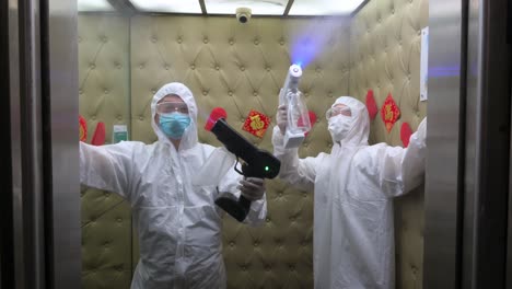 Empleados-Que-Usan-Desinfectante-En-Aerosol-Ppe-En-Un-Ascensor-En-Un-Spa-Como-Prevención-Contra-El-Virus-Covid-19-Durante-Su-Reapertura-En-Hong-Kong