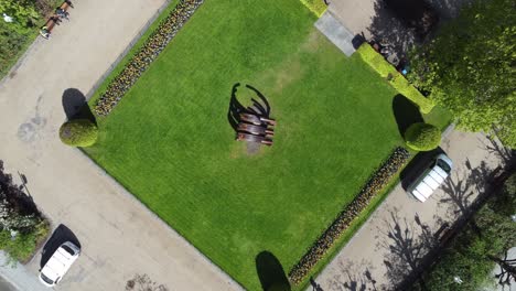 Upward-moving-top-down-view-of-Sæverud-sculpture-monument-in-Bergen-city-park---Norway-aerial