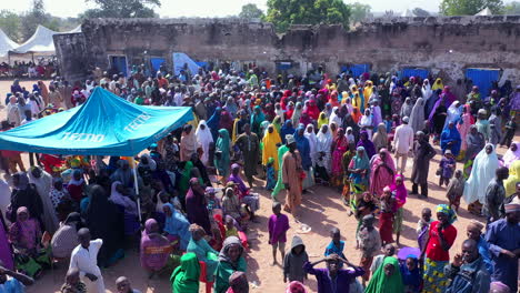 People-in-the-Niger-State-of-Nigeria,-west-Africa-gather-at-the-local-government-headquarters-to-receive-humanitarian-aid---aerial-view