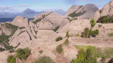 Impresionante-Vista-Aérea-De-La-Montaña-Rocosa-De-Montserrat,-Corredores-De-Maratón-Cruzando-Caminos,-Círculo-Pan,-Día