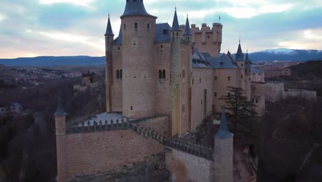 Ascending-Aerial-view-of-Segovia-Alcazar-and-city-during-sunrise-in-winter-cold-morning