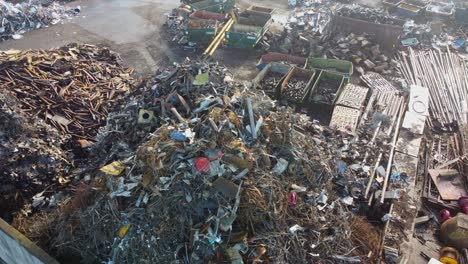 Huge-piles-of-waste-and-scrap-metal-for-recycling-in-scrap-yard---aerial-flying-over-scrap-at-Stena-recycling-in-Stavanger-Norway