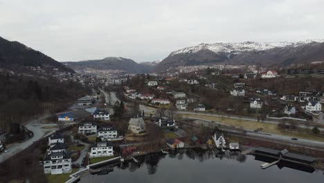 Vista-Aérea-De-La-Ciudad-De-Bergen-Vista-Desde-El-Lago-Nordasvatnet-Y-Krambua-Mirando-Contra-Danmarksplass-Y-El-Centro-De-La-Ciudad---Montaña-Ulriken-En-El-Fondo---Noruega-Aérea-Nocturna