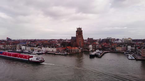 Vista-Aérea-Del-Círculo-Rodante-Del-Buque-De-Carga-Pasando-Por-Oude-Maas-Con-Nuestra-Señora-De-Dordrecht-Al-Fondo