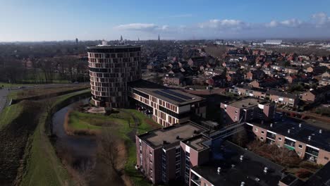 Blick-Auf-Die-Stadt-Mit-Wohngegend-Und-Farbenfrohem,-Runden,-Hoch-Aufragenden-Gebäude-Eines-Seniorenwohnheims-Mit-Servicewohnung-In-Der-Niederländischen-Turmstadt