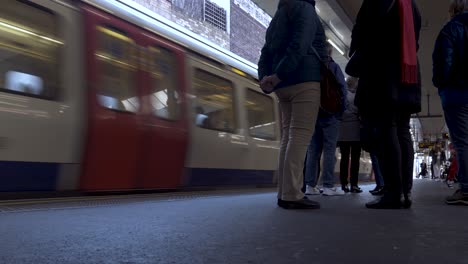 Met-Line-Train-At-Departing-At-Finchley-Road-Station-In-London-With-People-Waiting-On-Platform