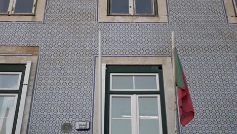 Bandera-Portuguesa-Caída-Por-Ventana-En-El-Típico-Edificio-De-Fachada-De-Azulejos-Pintorescos-En-Lisboa