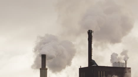 Acercar---Chimeneas-De-Fábrica-Con-Espacio-De-Copia-Que-Sale-Humo