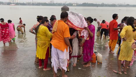 Die-Menschen-Nehmen-Kola-Bou-Mit,-Um-Im-Fluss-Ganges-Zu-Baden,-Was-Ein-Beliebtes-Ritual-Der-Durga-Puja-Ist