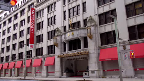 TOKYO,-JAPAN,-circa-April-2020:-signal-lighting-in-front-of-historical-department-store-Nihonbashi-Mitsukoshi-with-bronze-lions,-car-shows,-at-old-downtown-in-central-financial-district,-spring-day