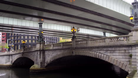 TOKYO,-JAPAN,-circa-April-2020:-historical-Nihonbashi-bridge,-highway-overhead,-reflection-over-the-river,-at-old-downtown-in-central-financial-district,-spring-day,-PAN