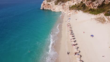 Turistas-Tomando-El-Sol-En-La-Playa-De-Milos,-Isla-De-Lefkada,-Grecia---Revelación-Aérea