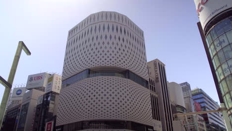 GINZA,-TOKYO,-JAPAN,-circa-April-2020:-as-cars,-trucks-driving-on-avenue-a-bird-flying-in-front-of-GINZA-PLACE-BLDG