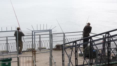 Männer-Mit-Angelruten-Angeln-Am-Pier-Von-Llandudno,-Bereiten-Die-Ausrüstung-Vor-Und-Warten-Voller-Vorfreude