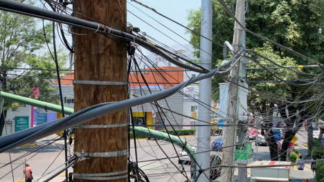 Close-Up-View-Of-Powerlines-Crossing-Street-With-Traffic-Passing-By-In-Mexcio-City