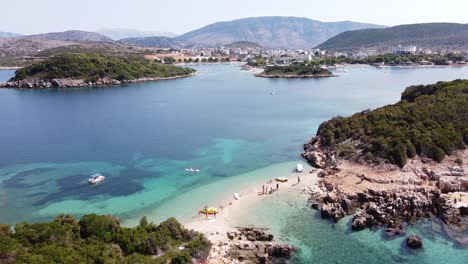 People-Relax-at-Small-White-Sand-Strip-at-Ksamil-Islands,-Albania---Aerial