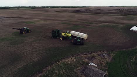 Toma-En-órbita-De-Un-Dron-Preparándose-Para-Sembrar-Un-Campo-Con-Un-Tractor-John-Deere