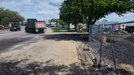 A-water-truck-and-a-dump-truck-leave-a-construction-site-in-Portland,-Maine